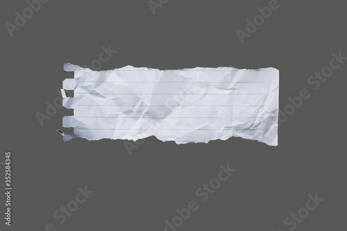 White ripped striped note, copybook, notebook paper stuck on light gray,black background.