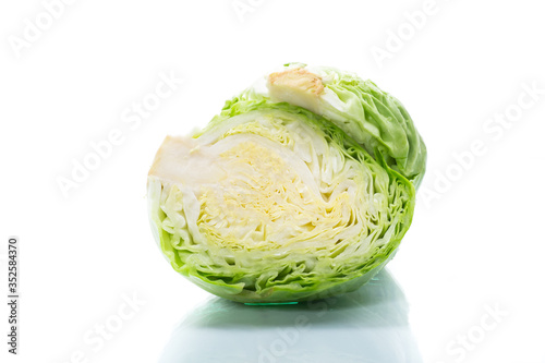 early green cabbage cut in half swing on a white background © Peredniankina