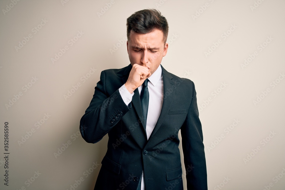 Young handsome business man wearing elegant suit and tie over isolated background feeling unwell and coughing as symptom for cold or bronchitis. Health care concept. Young handsome business man wearing elegant suit and tie over isolated background feeling unwell and coughing as symptom for cold or bronchitis. Health care concept.