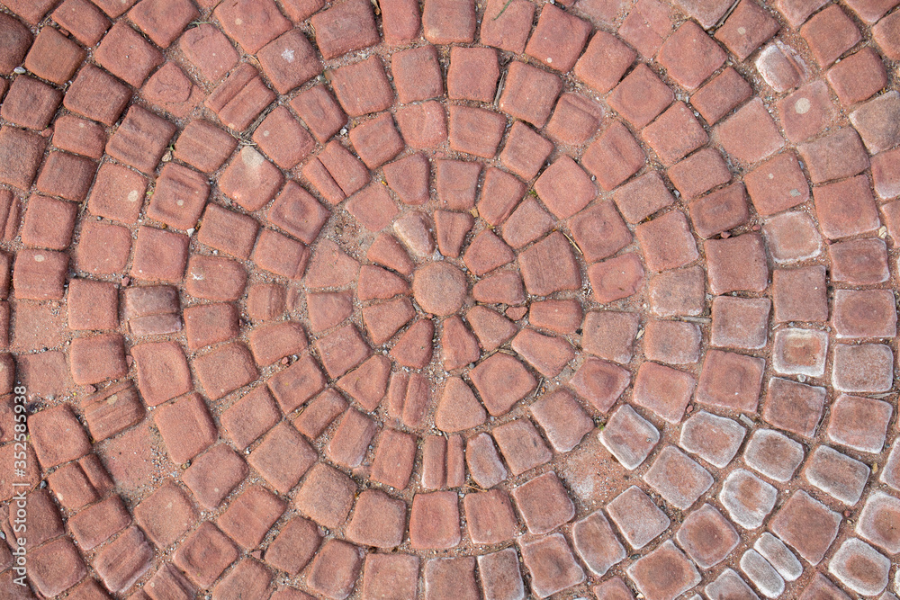Old, red bricks arranged in a circle. Cobblestone. Texture, embossed background. Old, red bricks arranged in a circle. Cobblestone. Texture, embossed background.