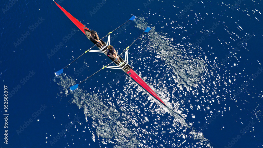 Naklejka premium Aerial drone photo of women athletes exercising sport canoe in open ocean deep blue sea
