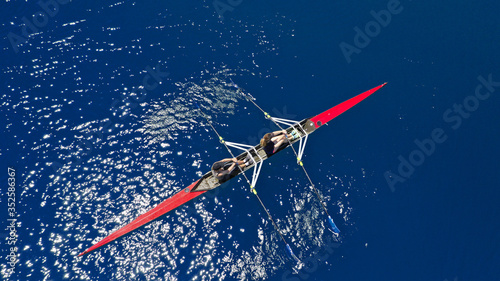 Aerial drone photo of women athletes exercising sport canoe in open ocean deep blue sea