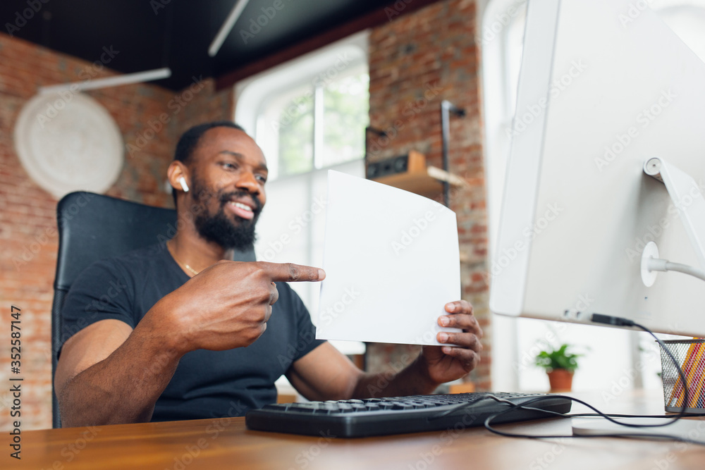 Pointing. Young man, businessman working in office, looking on blank black computer screen, monitor. Copyspace for your ad. Finance, business, work, gadgets and tech concept. Freelance, remote worker. Pointing. Young man, businessman working in office, looking on blank black computer screen, monitor. Copyspace for your ad. Finance, business, work, gadgets and tech concept. Freelance, remote worker.