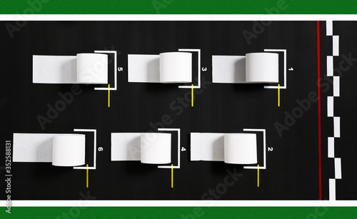 Rolls of toilet paper on the starting grid of motorsport. Concept of delayed start of the season in car racing.