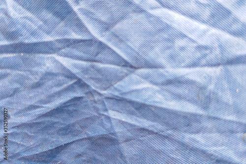Beautiful closeup background with dark gray crumpled raincoat fabric. Ideal for use in the design or wallpaper
