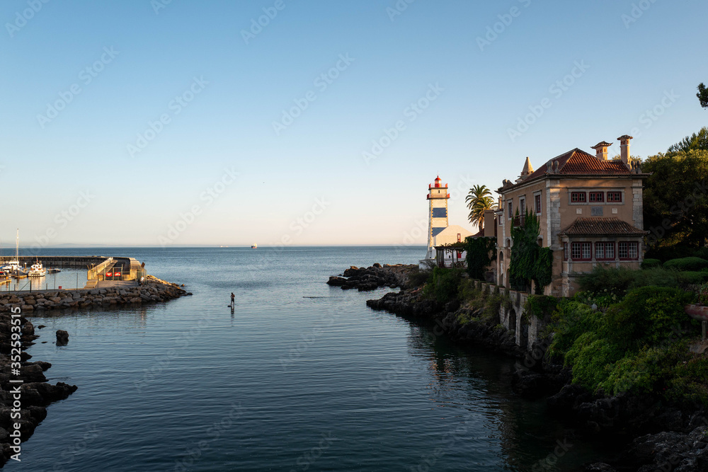 A man is paddling in the water below the Santa Maria lighthouse in Caiscas.