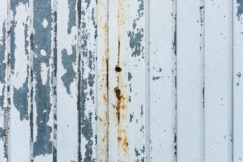 Metal aged door. Cracked white paint. Rusty lock on center.