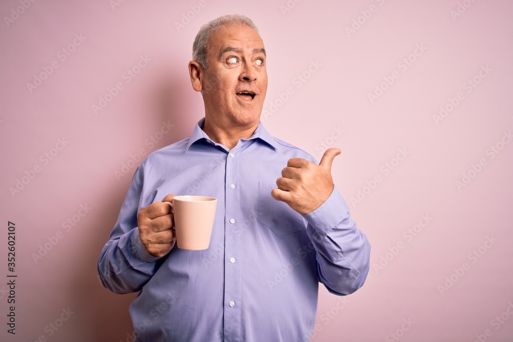 Middle age handsome hoary man drinking mug of coffee over isolated pink background pointing and showing with thumb up to the side with happy face smiling Middle age handsome hoary man drinking mug of coffee over isolated pink background pointing and showing with thumb up to the side with happy face smiling