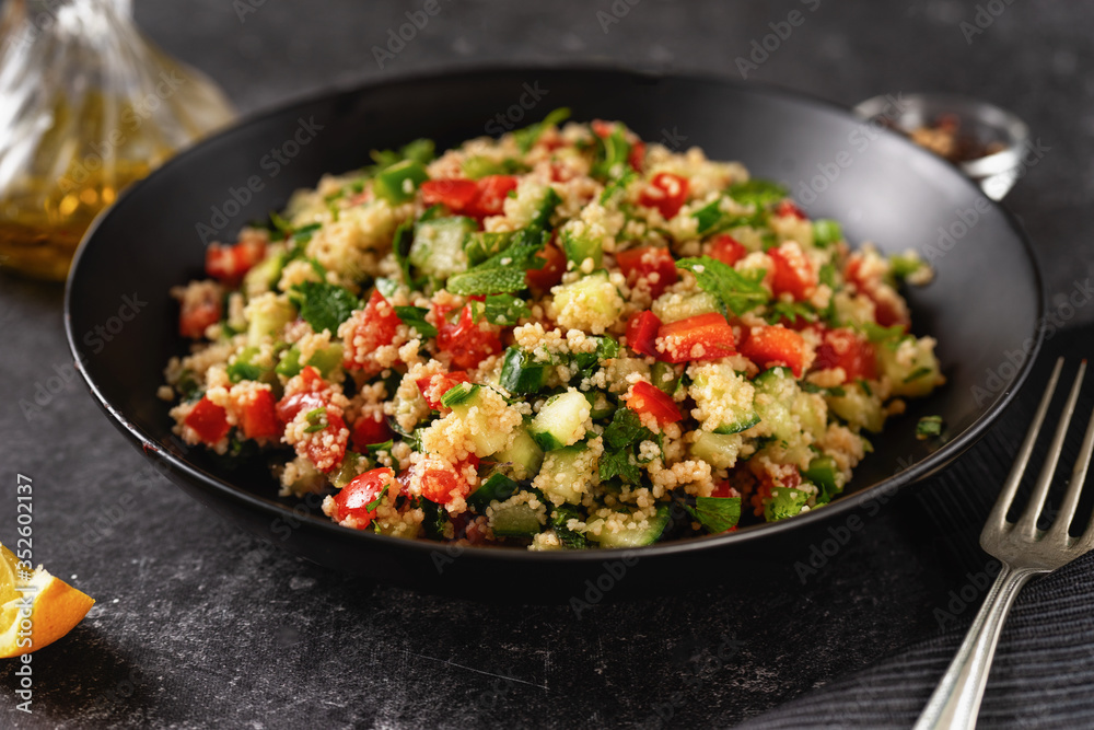 Close up of fresh and healthy vegan couscous salad on black Close up of fresh and healthy vegan couscous salad on black