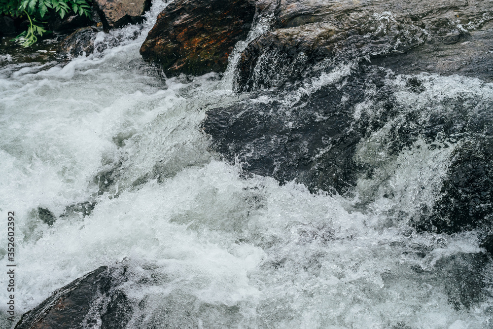 Full frame nature background of water riffle of mountain river. Powerful water stream of mountain creek with rapids. Natural textured backdrop of fast flow of mountain brook. Rapids texture close-up. Full frame nature background of water riffle of mountain river. Powerful water stream of mountain creek with rapids. Natural textured backdrop of fast flow of mountain brook. Rapids texture close-up.