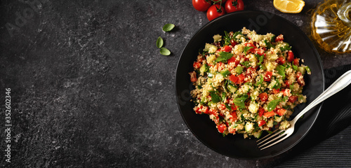 Fresh summer vegan couscous salad with vegetales and olive oil captured from above photo