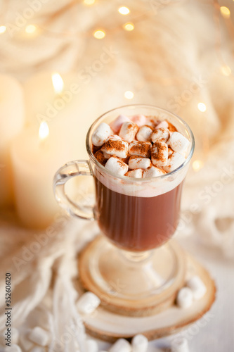 Winter hot drink: hot chocolate with marshmallow. Delicious sweet beverage. Christmas lights on background. Cozy home atmosphere, holiday festive mood. Close up, macro
