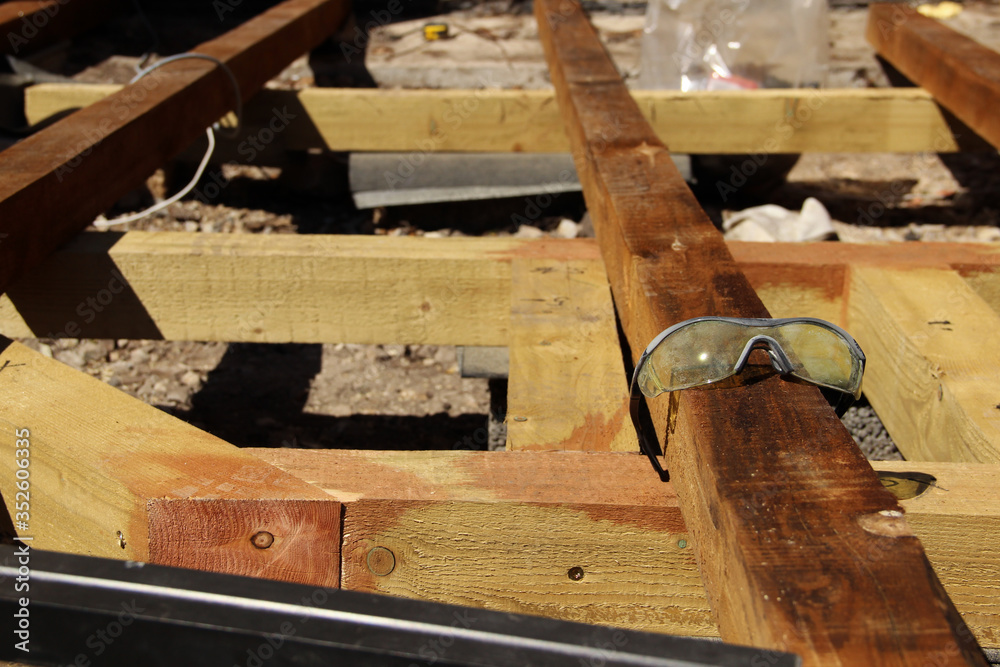 Plastic safety glasses. Used safety goggles lying on a beam. Plastic safety glasses. Used safety goggles lying on a beam.