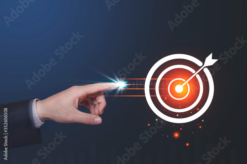 Human hand touching glowing point at target circle with light effects on dark blue background. Business goal setting concepts Mosquito nets focus on the core of an important destination.copy space.