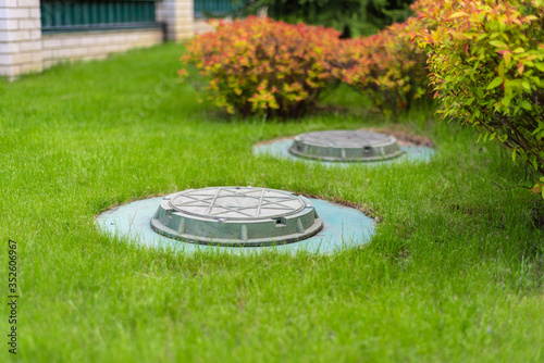 cesspool on the backyard green lawn photo