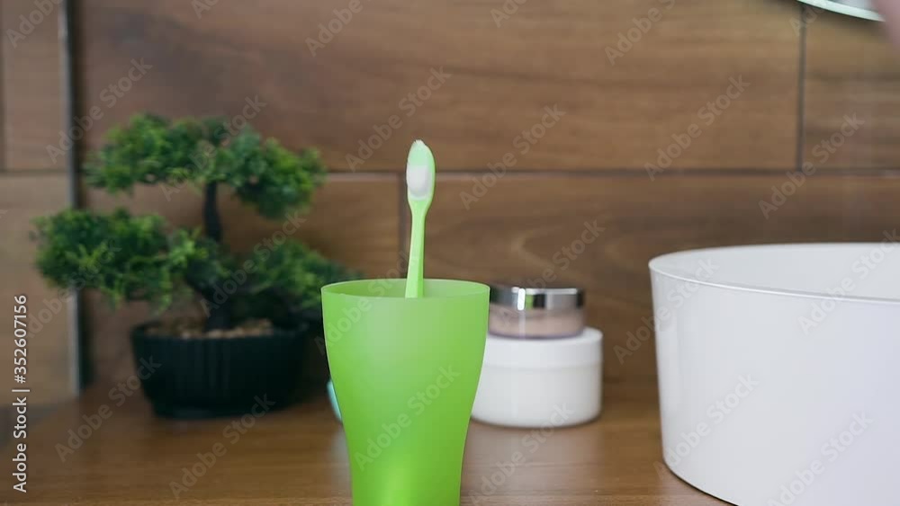 Healthy dental concept where somebody's hand doing choice between two toothbrushes before cleaning teeth Healthy dental concept where somebody's hand doing choice between two toothbrushes before cleaning teeth