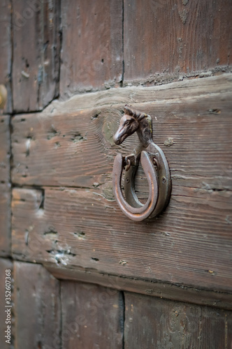 Decorative door knocker with horse head and horseshoe close up