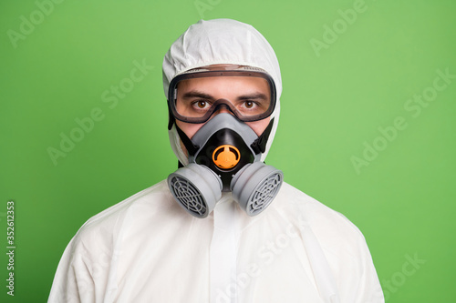 Close up photo of confident successful doctor man have respirator dont scary covid infection epidemic contamination wear hazmat uniform isolated over green color background