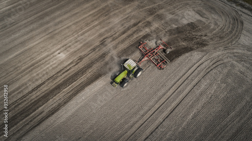 Farmers cultivating. Tractor makes vertical tillage. Aerial view © LALSSTOCK