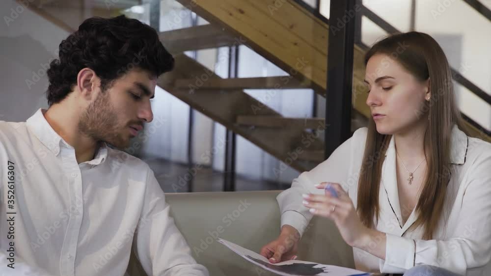Businessmen are discussing the company finance statement while sitting on sofa Businessmen are discussing the company finance statement while sitting on sofa