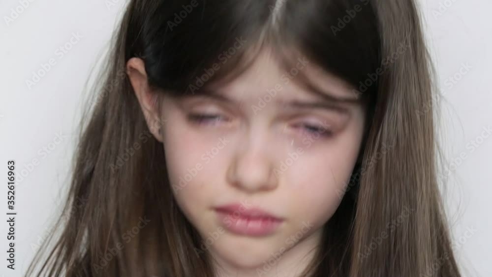 close-up portrait of a little beautiful crying girl on a white background close-up portrait of a little beautiful crying girl on a white background