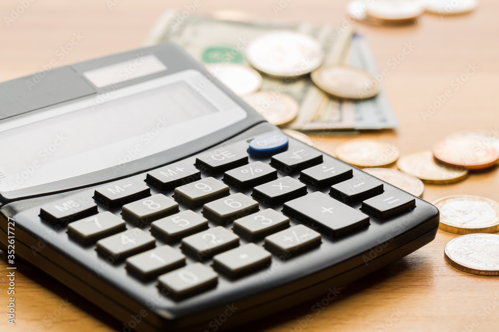 Coin money and banknote bills with a calculator. ballance reduction Coin money and banknote bills with a calculator. ballance reduction