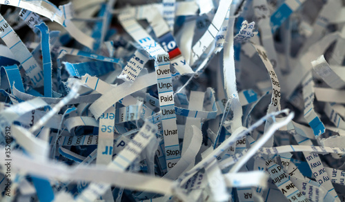 Shredded paper with the word PAID highlighted in the centre of the image
