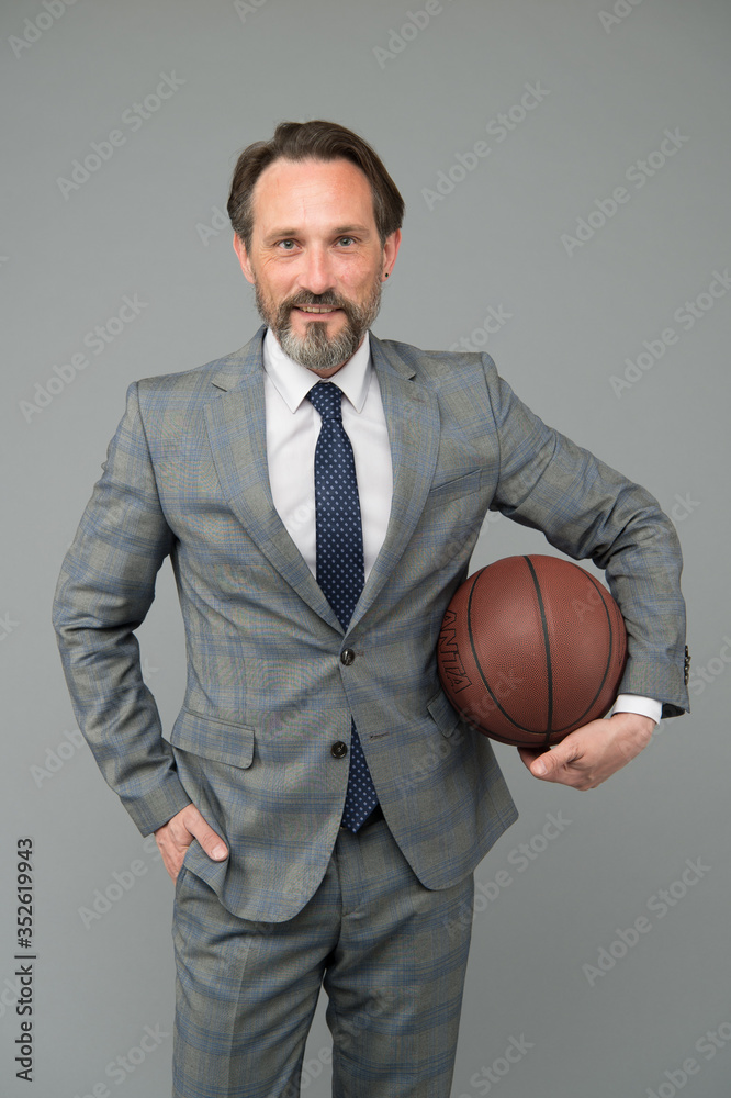 Ambitious coach. Business coach hold basketball ball. Basketball coach grey background. Confident coach or teacher in formalwear. Strategy and management. Professional at training