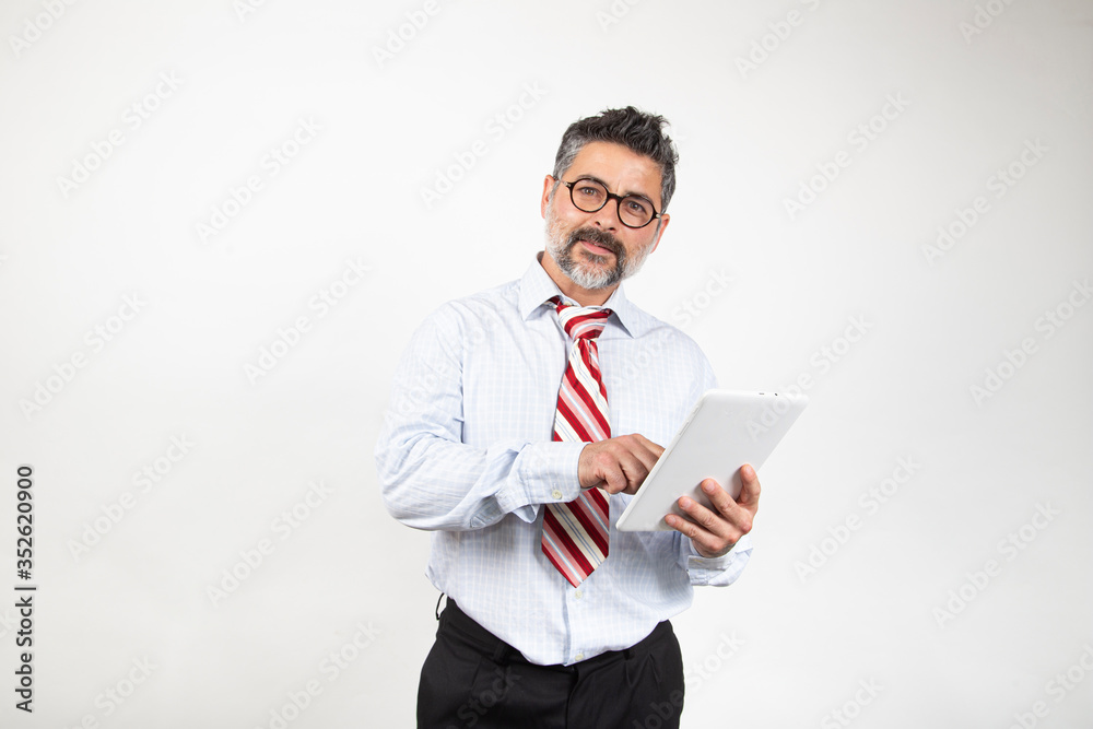 Businessman with glasses is using a digital tablet and smiling, isolated on white background. Looking to the camera Businessman with glasses is using a digital tablet and smiling, isolated on white background. Looking to the camera