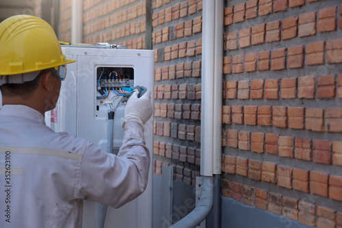 air-conditioning installation technician is about to repair air conditioning in homes and buildings.Air conditioner repairmen work on home unit.