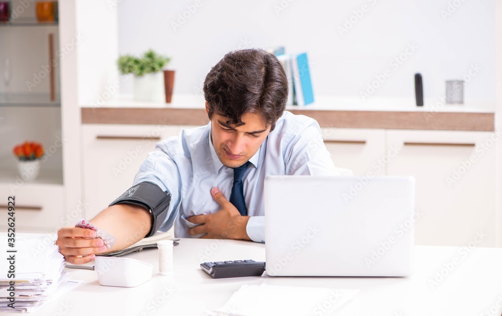 Man under stress measuring his blood pressure Man under stress measuring his blood pressure