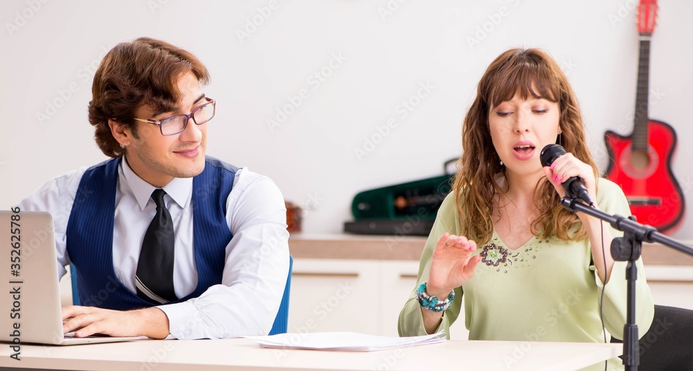 Young woman during music lesson with male teacher Young woman during music lesson with male teacher