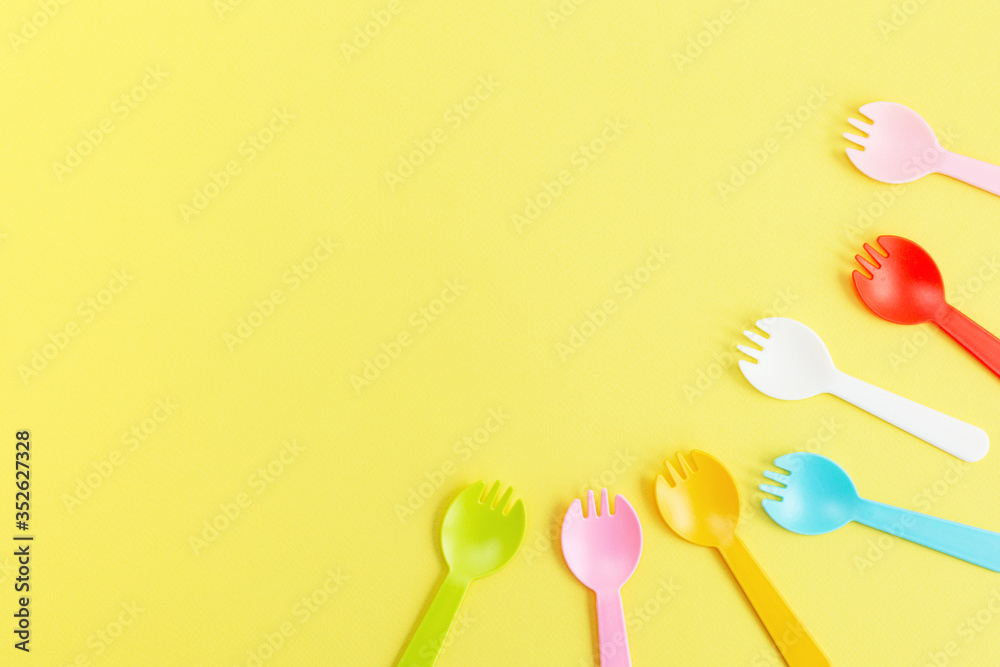 Flat lay plastic forks on yellow background Flat lay plastic forks on yellow background