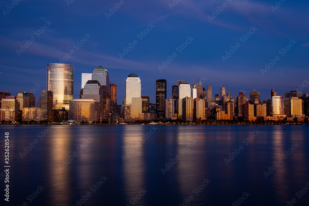 New York City skyline at twilight with reflection on the Hudson River