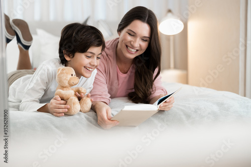 Woman and her son reading a book together