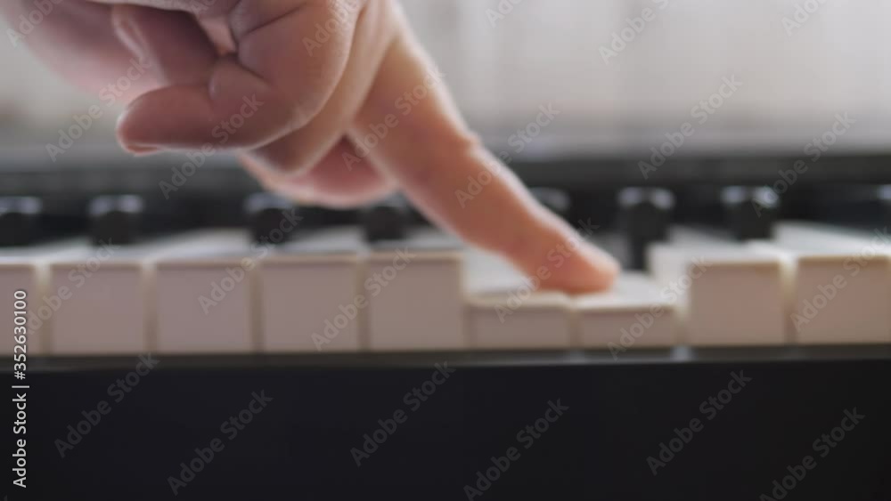Electronic piano. Fingers press the piano keys. Swipe one finger across all the piano keys. Music lesson.