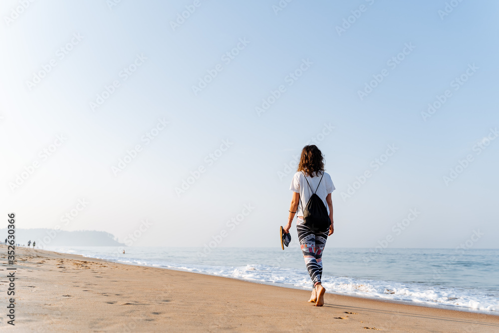 girl walking on the beach, barefoot on the beach, on the beach, walk by the sea at dawn, barefoot on the sand, shale in hand, on the beach, morning walk, walking barefoot, sand, waves, Goa, dawn, morn