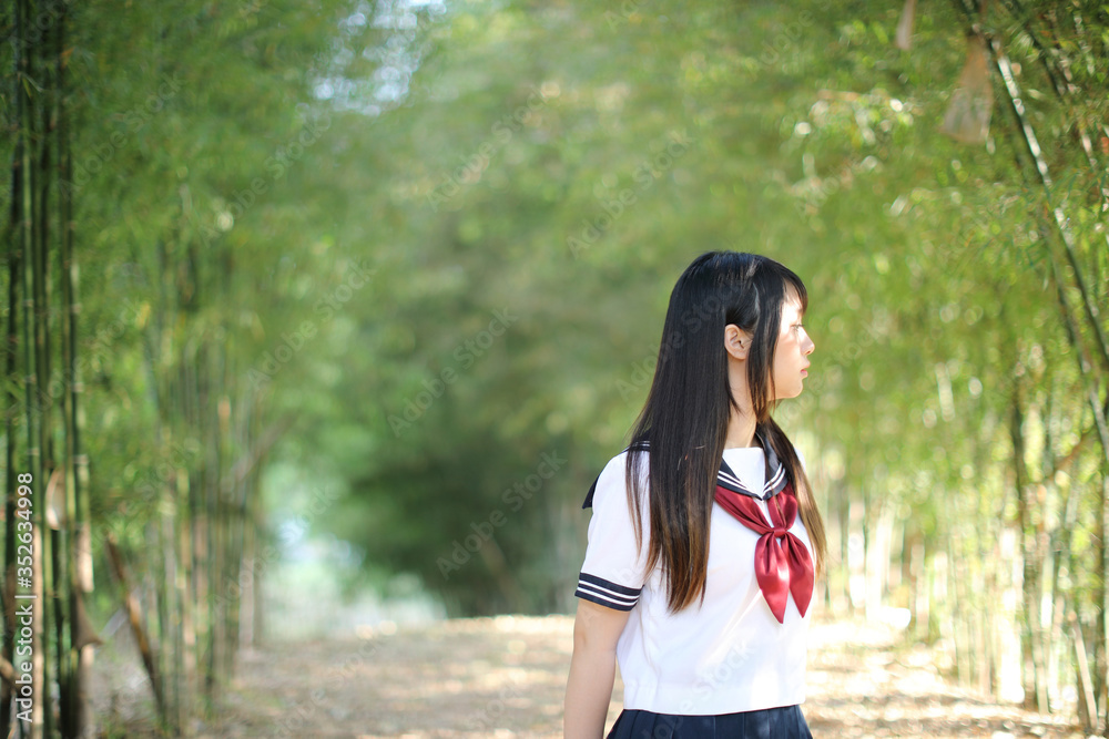 Portrait of beautiful Asian japanese high school girl uniform looking with bamboo forest background Portrait of beautiful Asian japanese high school girl uniform looking with bamboo forest background