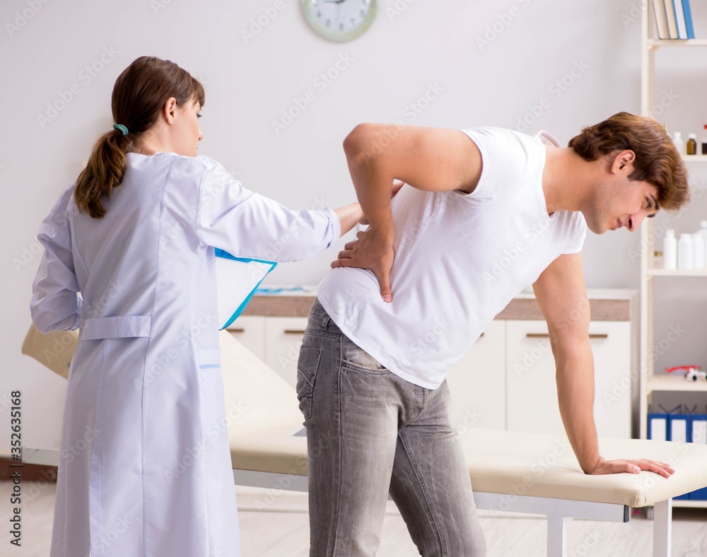 Male patient visiting young female doctor chiropractor