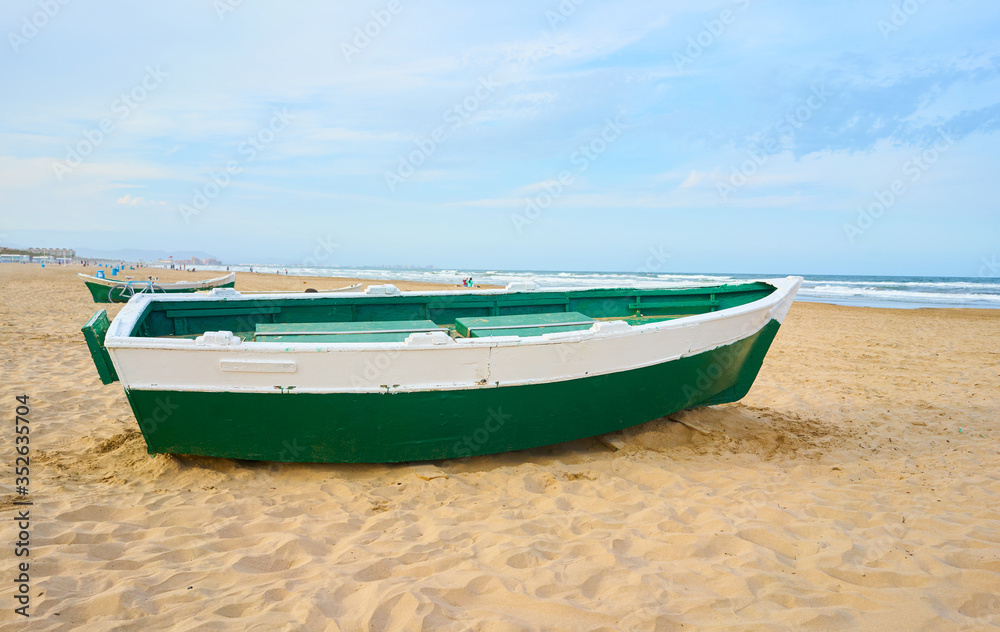 Naklejka premium Green boat in the sand on the beach