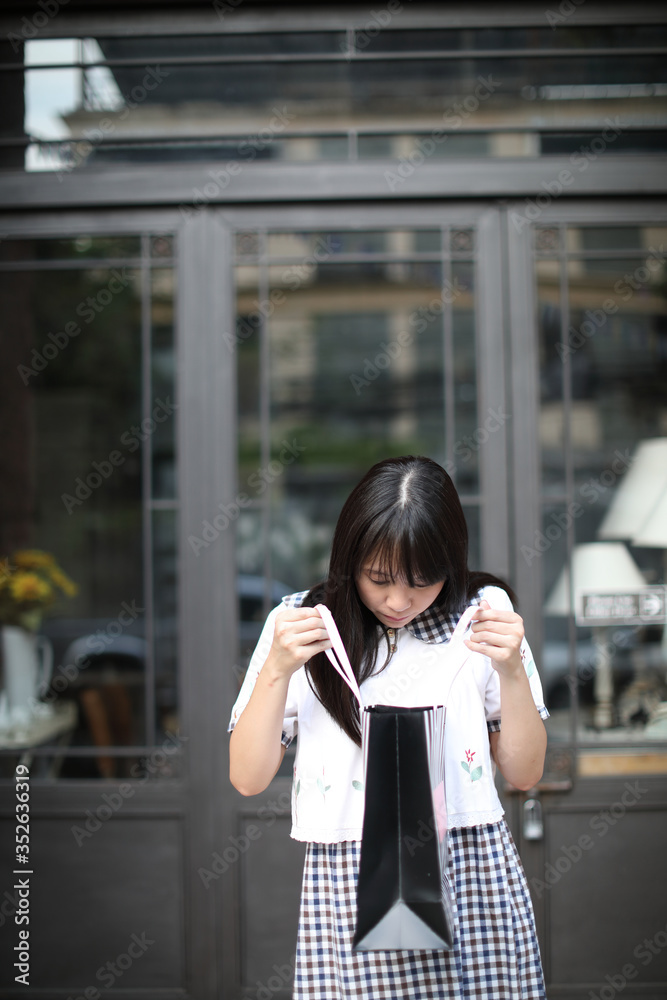 Fototapeta premium Asian Young woman with shopping bag in normal lifestyle at urban city