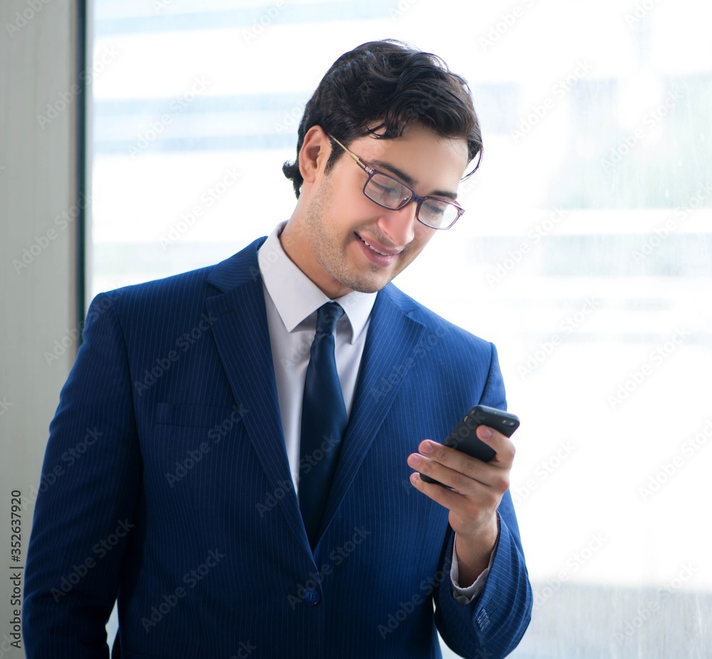 Young handsome businessman standing at the window Young handsome businessman standing at the window