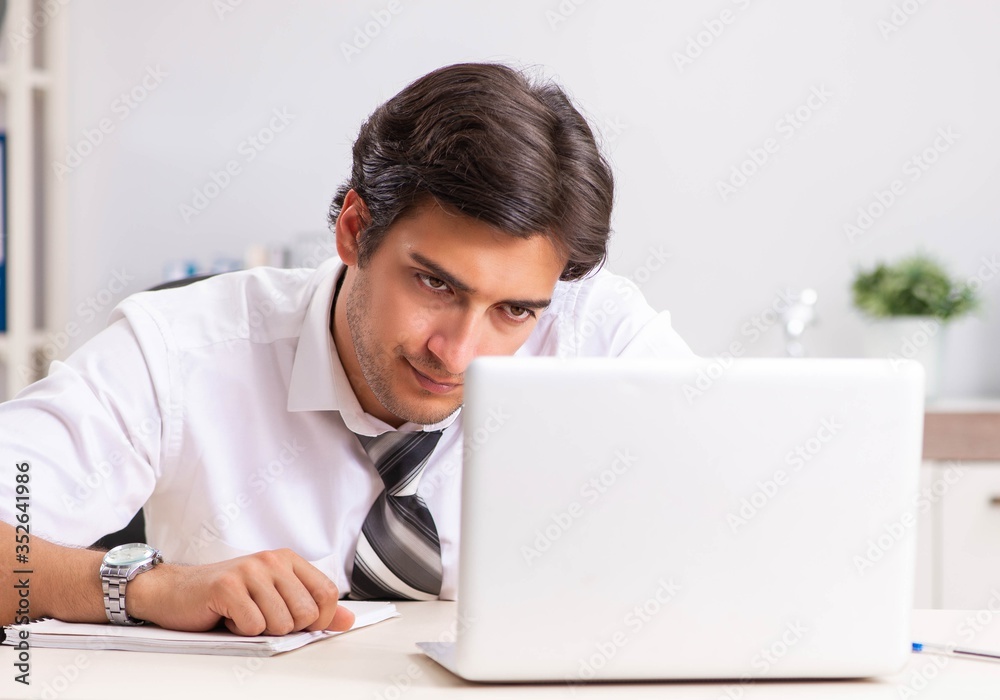 Young handsome businessman working in office Young handsome businessman working in office
