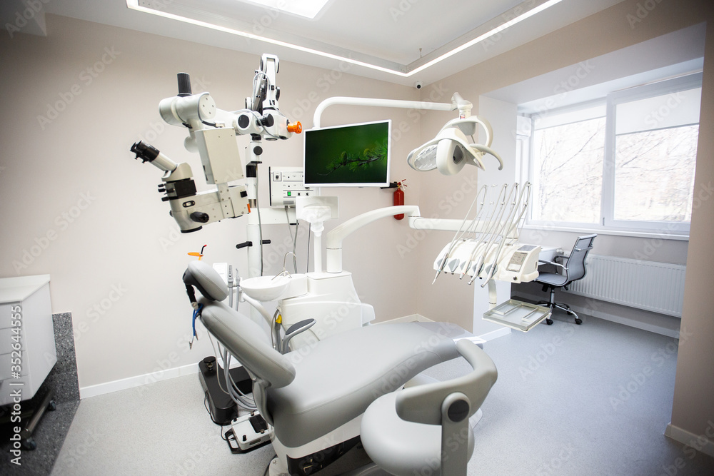 Modern Dental Clinic, Dentist chair and other accessories used by dentists in medical light. Dental surgeon, is a surgeon . Dentist's office. Dental equipment in modern, clean interior