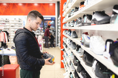 Young man looking for sports equipment at sports shop