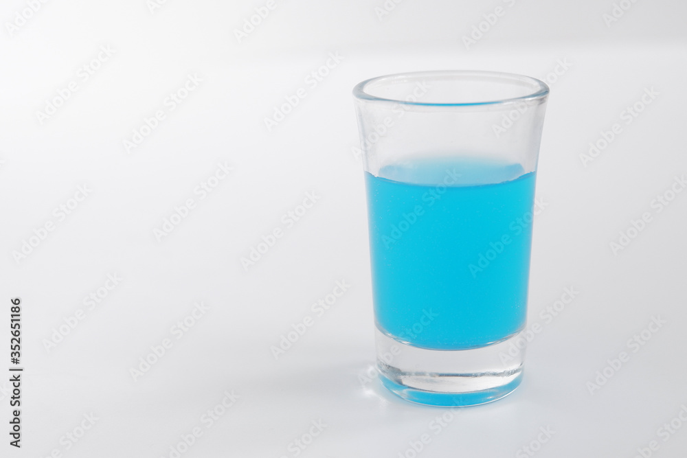 Glass of blue alcohol. Shot of blue in a glass. Glass of blue alcohol. Shot of blue in a glass.