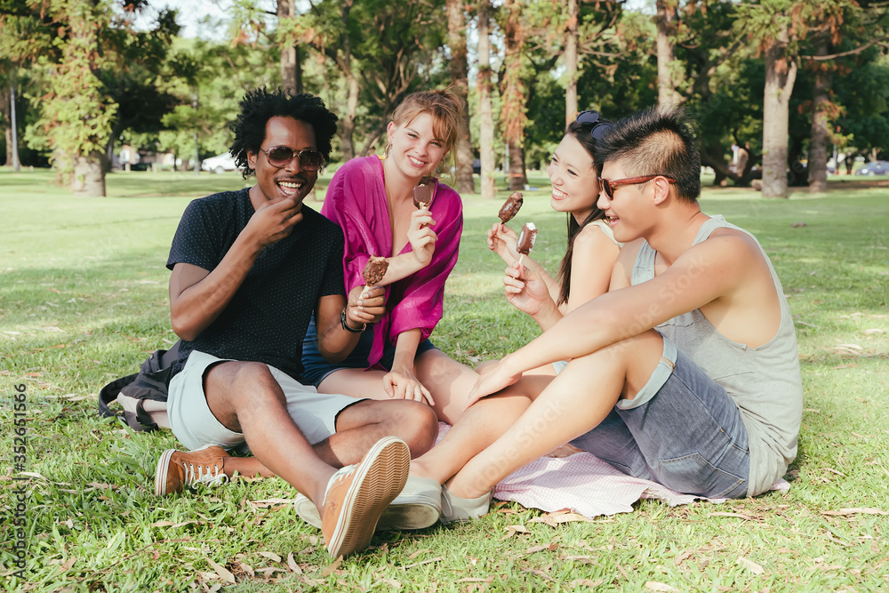A group of friends having ice cream together in a park