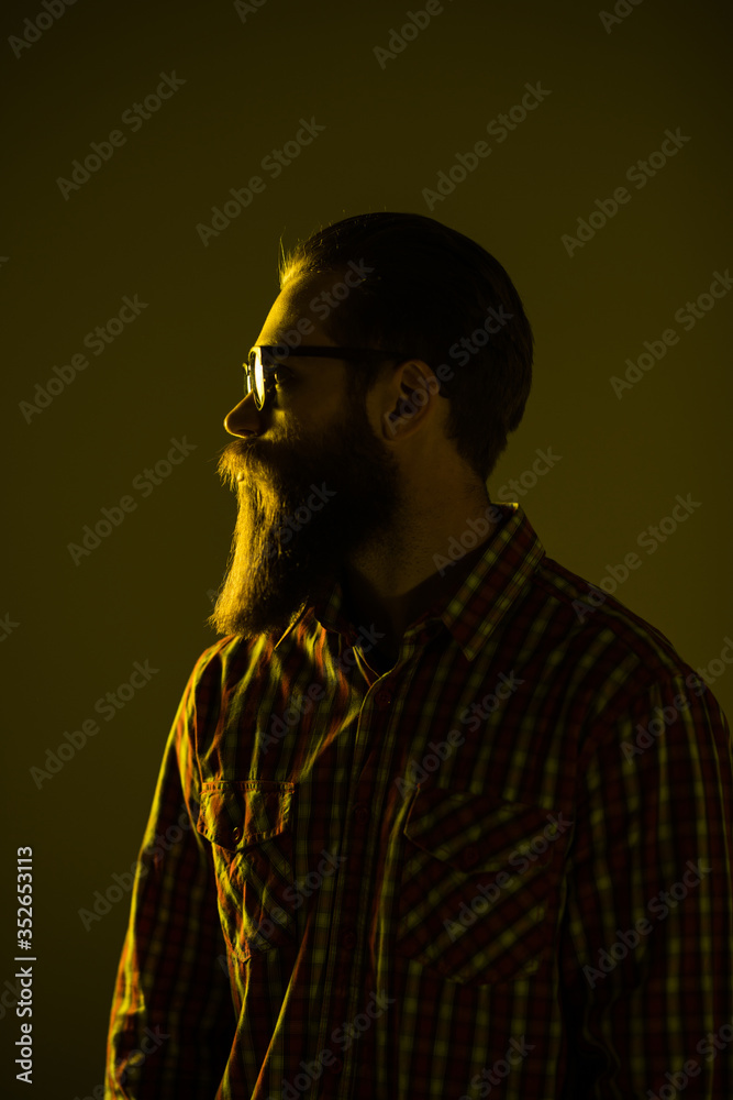Young bearded man wear in sunglasses with crossed hands isolated on light background.