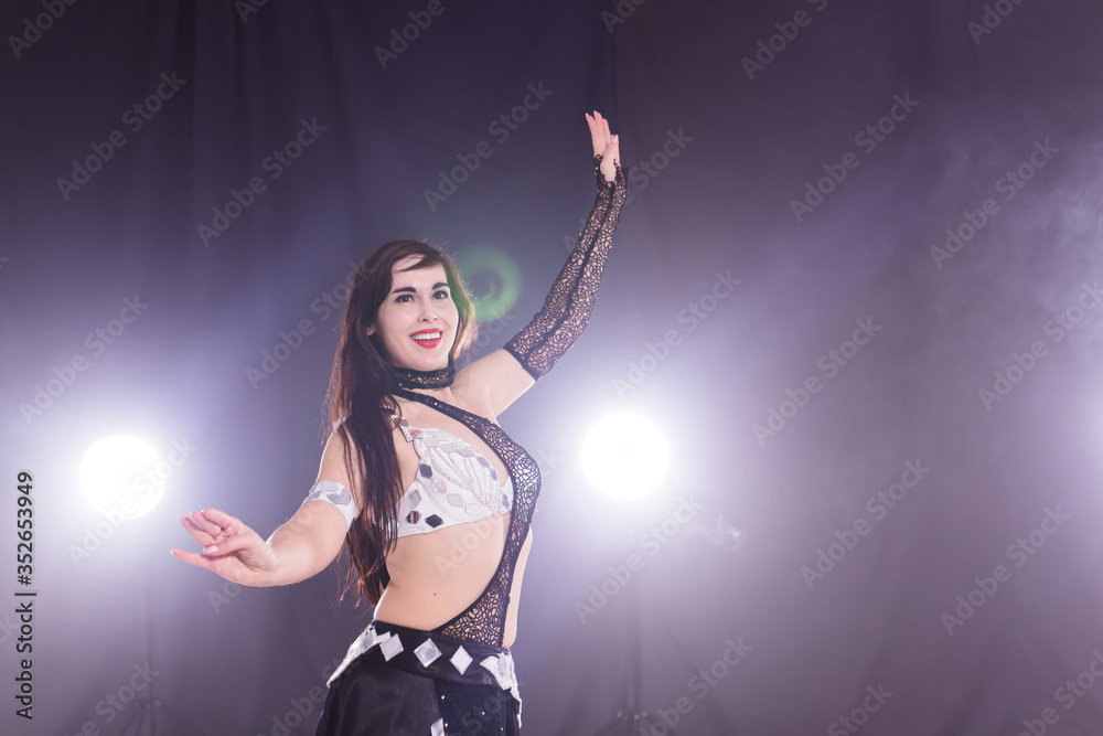 Girl dancing belly dance, fusion or tribal. A woman in a beautiful costume demonstrates charming and gentle movements in the dance. Copy space.