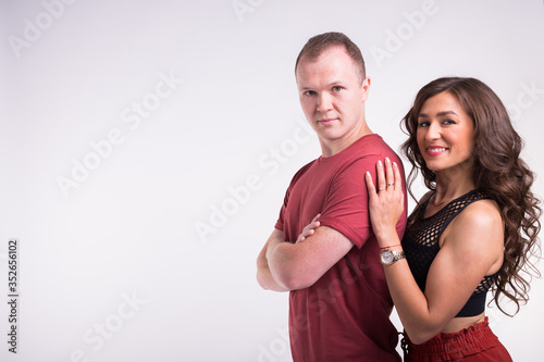 Portrait of young healthy sporty couple hugging on white background with copy space.